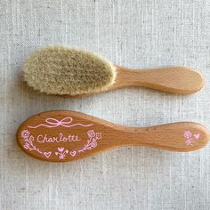 two wooden brushes sitting on top of a white cloth covered table next to each other