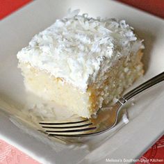 a piece of coconut cream cake sitting on top of a white plate with a fork