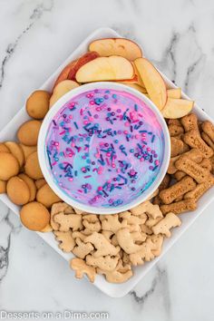 a bowl of dip surrounded by crackers and apples on a marble counter top with text overlay