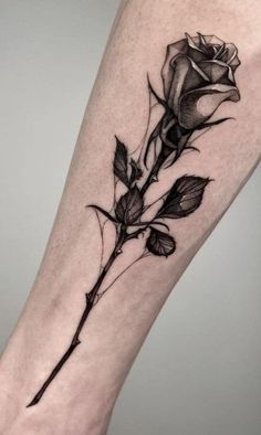 a black and white rose tattoo on the leg