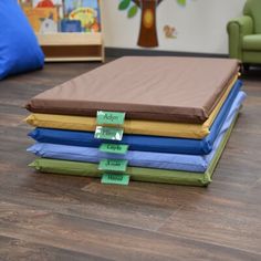 a stack of different colored sheets sitting on top of a wooden floor