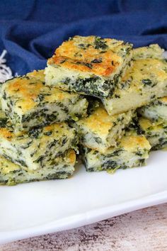 a white plate topped with spinach and cheese squares