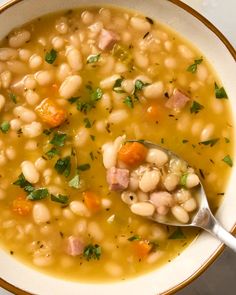 a white bowl filled with beans and ham