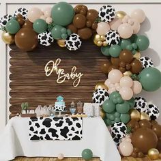 a baby shower is decorated with balloons, cow print table cloths and an animal theme