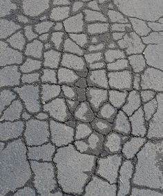 the pavement is made up of cobblestones and has cracks in it to make them look like they have been cracked