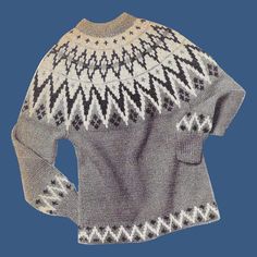 an old sweater with black and white designs on the back, against a blue background