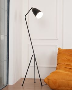 a black floor lamp next to a yellow pillow