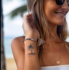 a woman with a palm tree tattoo on her arm