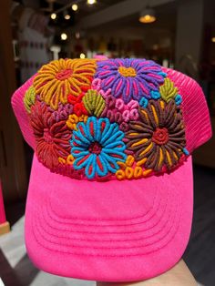 Hand-embroidered in Chiapas, Mexico, these Floral Caps are one-of-a-kind and masterfully crafted pieces. The cap features a vibrant array of flowers, perfect for bringing a pop of color and a touch of style to your look! Perfect for summer, this beautiful cap features a mesh rear for breathability and also has an adjustable head strap! Multicolor Flower-shaped Summer Hat, Summer Multicolor Flower Hat, Summer Multicolor Flower-shaped Hat, Summer Flower-shaped Multicolor Hat, Multicolor Spring Visor Hat, Embroidered Trucker Baseball Cap For Beach, Colorful Adjustable Spring Hats, Bohemian Pink Flower Hat, Pink Bohemian Flower Hat