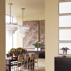 a dining room table with chairs and chandelier hanging from it's ceiling