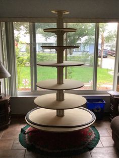 three tiered cake stand sitting in front of a window