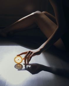 a person reaching for an orange slice with their hand on the floor in front of them