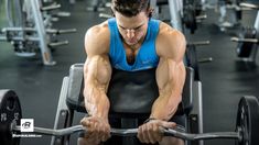 a man is working out with his hands on the barbells in a gym