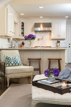 a living room filled with furniture and a kitchen in the backgroung area