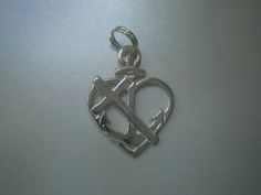 a silver heart shaped charm with scissors on it