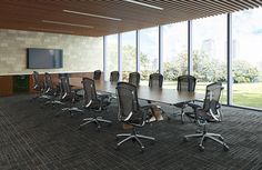 an empty conference room with chairs and a flat screen tv on the wall in front of large windows