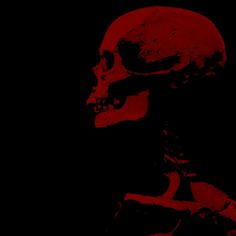 a skeleton with red paint on it's face and neck, standing in front of a black background