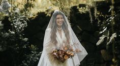 a woman wearing a veil and holding a bouquet