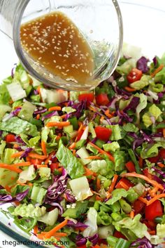 a glass bowl filled with salad and dressing