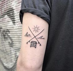 a man's arm with two crossed arrows and a camper van on it