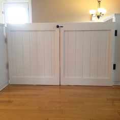 an empty room with wooden floors and two doors leading to the other side of the room