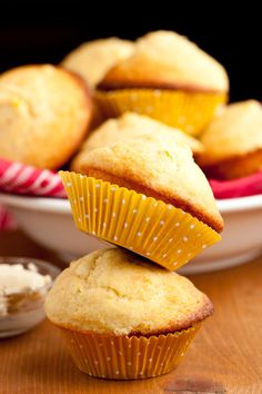 several muffins stacked on top of each other in front of a bowl of cream cheese