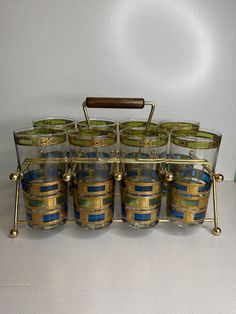 a set of six glass jars with gold rims and blue stripes on the lids