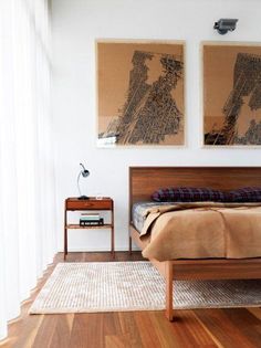 a bed room with a neatly made bed and two pictures on the wall above it