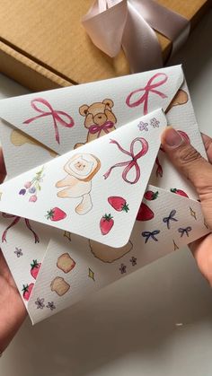 someone is holding three envelopes with stickers on them and one has a teddy bear