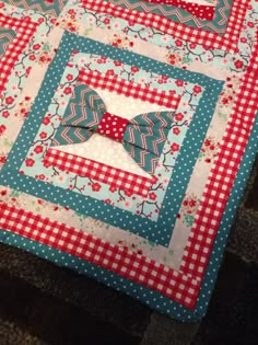 a close up of a quilted table runner with red and white checkered squares