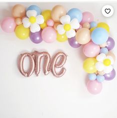 balloons are arranged around the word one