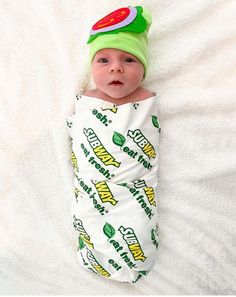 a baby is laying down wearing a green hat