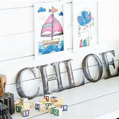 the word child spelled out in metal letters on a white mantle with toys and books