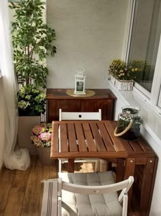 a wooden table sitting on top of a hard wood floor next to a potted plant