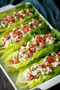 lettuce and pasta salad on a plate next to another dish with dressing in it