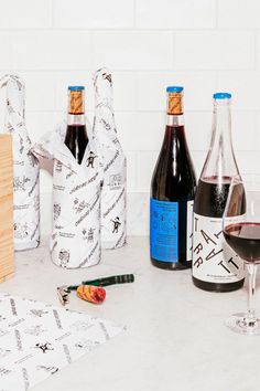 several bottles of wine are sitting on the counter next to some paper towels and corkscrews