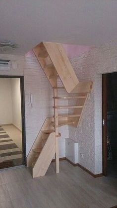 an empty room with wooden stairs and white walls