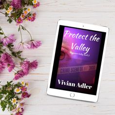 a tablet with the title protect the valley on it next to some pink flowers and daisies