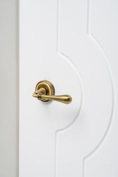 an open door with a brass handle on the front and side panel, in white painted wood