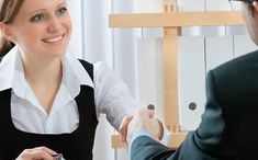 a man and woman shaking hands in an office setting