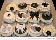 a box filled with lots of cupcakes covered in white frosting and black icing