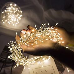 a person is holding some lights in their hand while they are sitting on a table