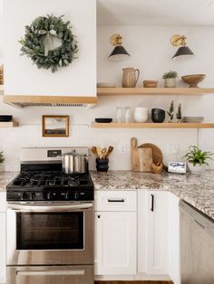 a stove top oven sitting inside of a kitchen next to a wall mounted pot rack