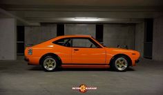 an orange car parked in a parking garage with the caption's above it