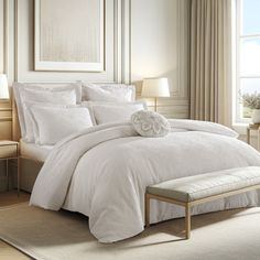 a bed with white sheets and pillows in a room