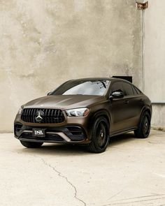 a brown mercedes suv parked in front of a building