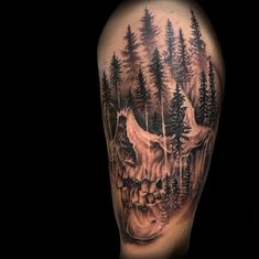 a man's half sleeve with an animal and trees on the left side of his arm