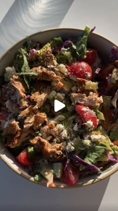 a bowl filled with salad and dressing on top of a table