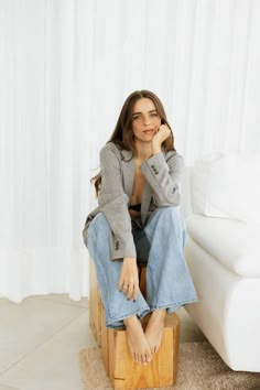 a woman sitting on top of a wooden block