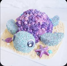 there is a cake made to look like a turtle and starfish on the beach